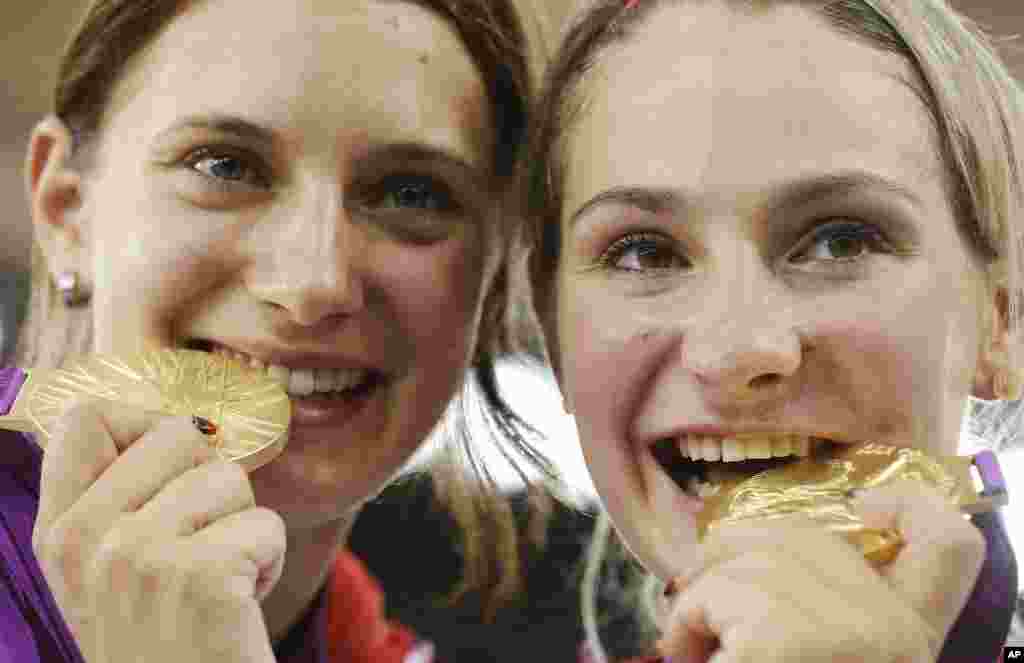 Germany's Kristina Vogel, right and teammate Miriam Welte, bite their gold medals after winning the women's team sprint track cycling event at the 2012 Summer Olympics, Aug. 2, 2012, in London.