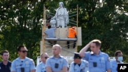 City workers cover the statue of Christopher Columbus at Marconi Plaza, Tuesday, June 16, 2020, in the South Philadelphia neighborhood of Philadelphia. (AP Photo/Matt Slocum)