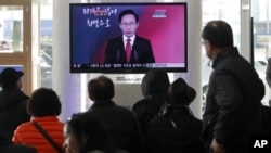 People watch a TV screen reporting South Korean President Lee Myung-bak delivers New Year's speech to the nation, at the Seoul Train Station in Seoul, South Korea, January 2, 2012.