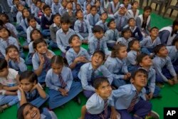 School children look at a drone camera during the inauguration ceremony of a water filtration tower at their school in Nai Basti Village, near New Delhi, India, March 22, 2017.