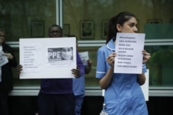 Hospital workers hold placards with the names of their colleagues who have died from coronavirus as they take part in a protest calling on the British government to provide PPE (personal protective equipment) across Britain.