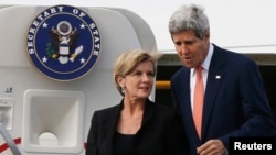 U.S. Secretary of State John Kerry (R) steps off his aircraft alongside Australia's Foreign Minister Julie Bishop in Sydney, August 11, 2014.