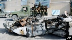 Tentara Somalia mengamati puing-puing mobil yang meledak di komplek istana Presiden di Mogadishu (8/7). 