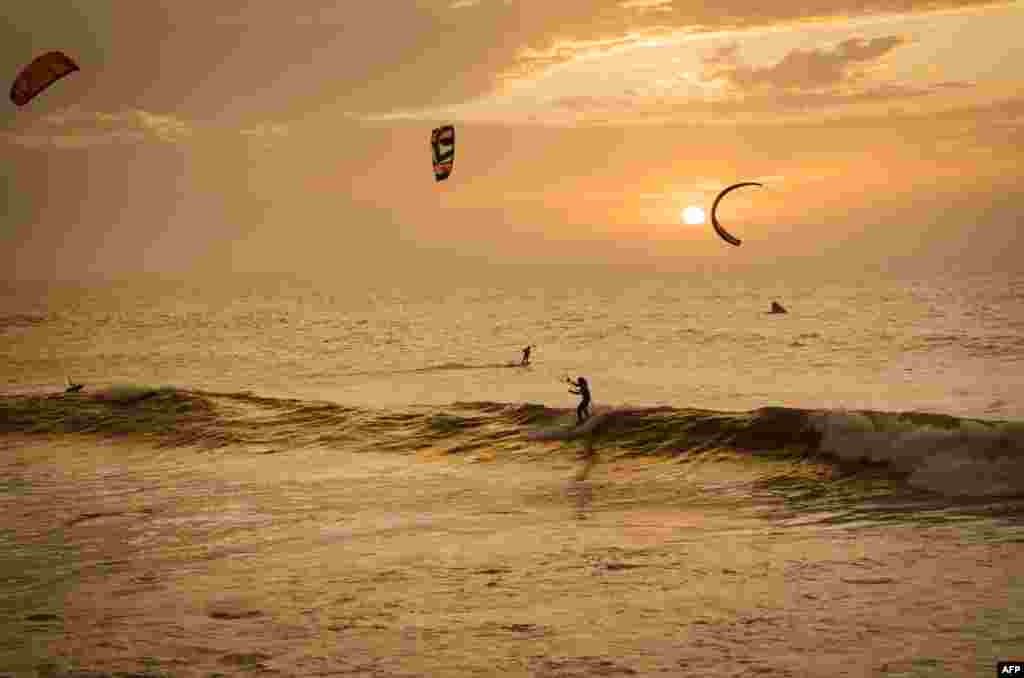 Kitesurfers ride waves at sunset at Dakhla beach in Morocco-administered Western Sahara.
