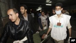 Medics carry an injured anti-government protester at a makeshift clinic outside Sana'a University, March 8, 2011