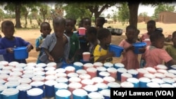 Les élèves de l'école primaire publique de Louanga à l’heure de la distribution de la nourriture, Togo, 23 mai 2017. (VOA/Kayi Lawson).