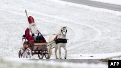 FILE - A man dressed as Santa Claus rides a carriage drawn by a pony as he travels through southern Germany, December 2017. (AFP PHOTO/Thomas Warnack)