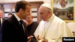Pope Francis exchanges gifts with French President Emmanuel Macron during private audience at the Vatican, June 26, 2018. 