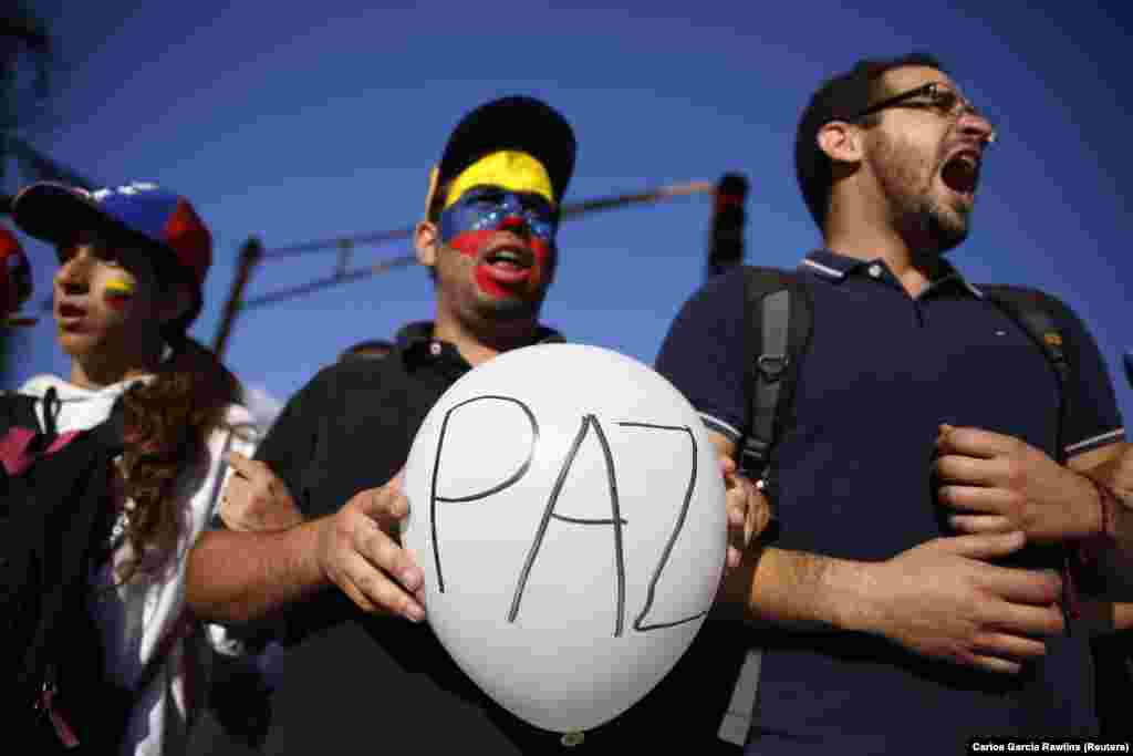 Apoiadores do líder da oposição, Leopoldo Lopez, gritam durante um comício para promover a paz em Caracas, 20 de Fevereiro de 2014. As forças de segurança venezuelanas e manifestantes se enfrentaram nas ruas bloqueadas por barricadas em chamas em várias cidades provinciais na quinta-feira.