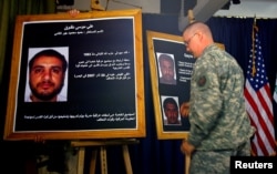 FILE - A U.S. soldier shows a picture of Ali Musa Daqduq during a news conference at the heavily fortified Green Zone area in Baghdad, July 2, 2007.
