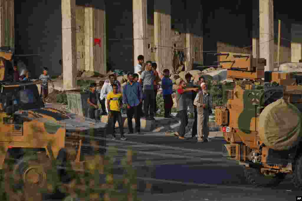 Poco después de que comenzara la operación turca dentro de Siria, los residentes locales aplauden cuando un convoy de vehículos de las fuerzas turcas atraviesa la ciudad de Akcakale, provincia de Sanliurfa, en el sureste de Turquía, en la frontera entre Turquía y Siria, el miércoles 9 de octubre. (Foto AP / Lefteris Pitarakis).