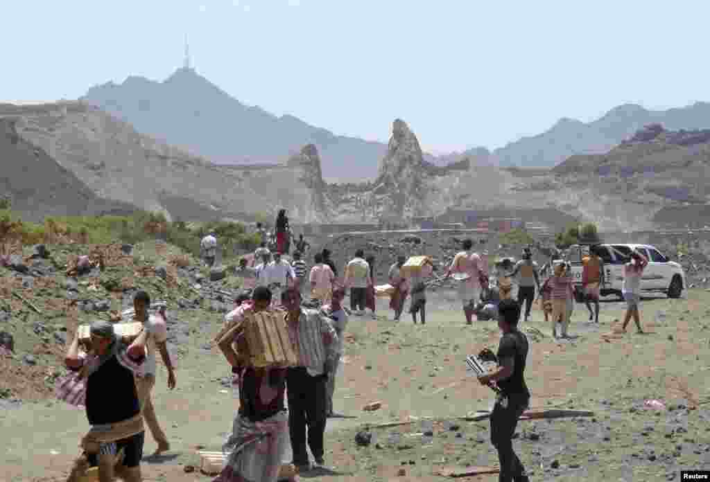 People loot boxes of ammunition that they took from an army depot in Aden, March 27, 2015.