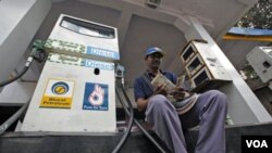 Seorang pekerja menghitung uang di pompa bensin di Mumbai, India. Kenaikan harga minyak mengakibatkan inflasi di Asia.