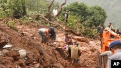 Rescue workers carry the body of a victim at the site of a landslide in Malin village, in the western Indian state of Maharashtra, July 30, 2014. 