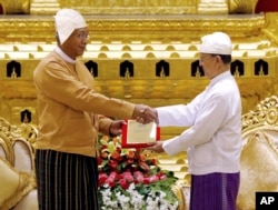 Myanmar's new president Htin Kyaw, left, receives the presidential seal from outgoing president Thein Sein, during a handover ceremony in Naypyitaw, March 30, 2016.