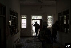 Federal policemen inspect the interior of a house as fighting against Islamic State militants continues on the western side of Mosul, Iraq, March 29, 2017.