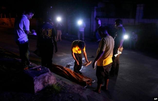 Funeral workers prepare to remove the body of a crime suspect after he was killed in gunbattles, Aug. 17, 2017 in Manila, Philippines.