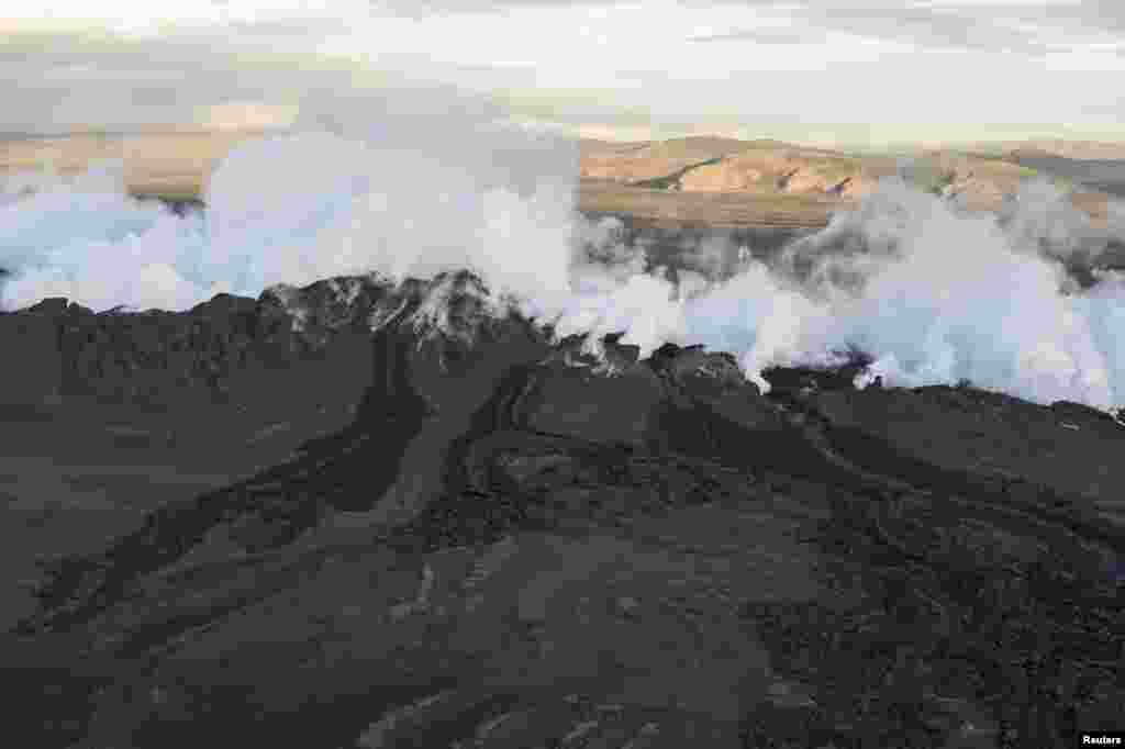 Steam and smoke rise over the fissure at the tip of a magma dyke around 40 km from the main Bardarbunga crater, Aug. 29, 2014