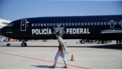 Migrante hondureño camina frente al avión mexicano que lo devolció a su país.