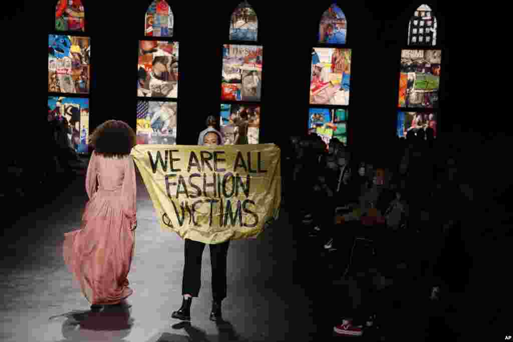 An activist displays a banner during Dior&#39;s Spring-Summer 2021 fashion collection presented during the Paris fashion week in Paris, France.