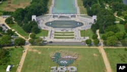 志愿者星期四在华盛顿国会大草坪上组成国家公园徽标 （2016年8月25日）