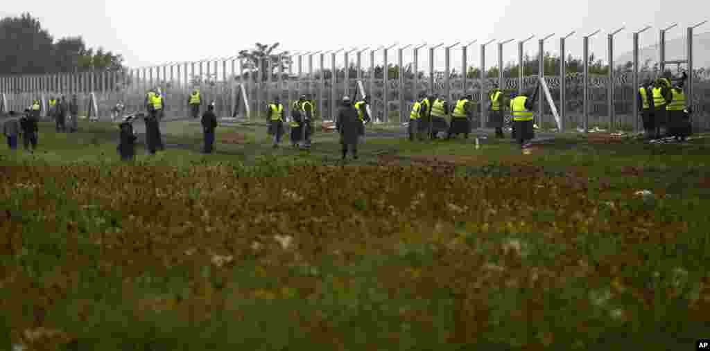 Hungarian workers build a partially constructed fence at their border with Serbia near Roszke. Hungary has been widely criticized for its treatment of refugees, compared to Germany and Austria.