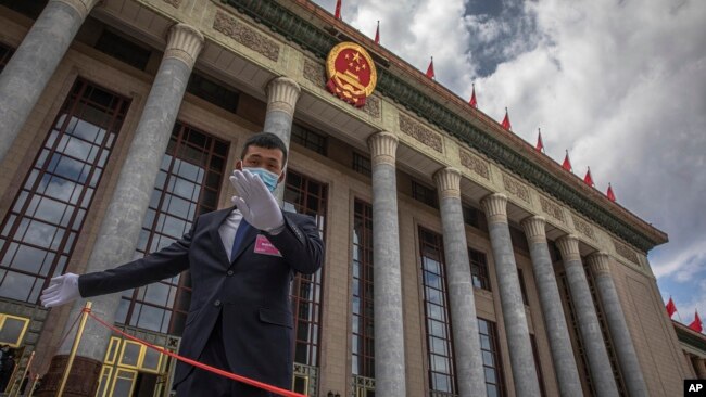 一名中国保安官员在正在举行全国人大会议的北京人大会堂外警卫。（2020年5月25日）