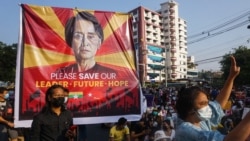 FILE - A banner featuring Aung San Suu Kyi is displayed as protesters take part in a demonstration against the military coup in front of the National League for Democracy (NLD) office in Yangon on February 15, 2021.