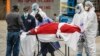 Zdravstveni radnici bolnice u Bruklinu utovaruju posmrtne ostatke u hladnjaču, koja služi kao privremena mrtvačnica (Foto: AP/John Minchillo)