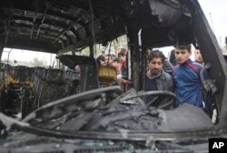 Citizens inspect the scene after a car bomb explosion at a crowded outdoor market in the Iraqi capital's eastern district of Sadr City, Iraq, Jan 2, 2017.