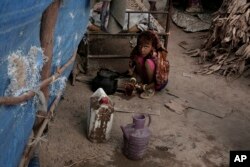 In this Feb. 15, 2018 photo, Awsaf, a thin 5-year-old who is getting no more than 800 calories a day from bread and tea, half the normal amount for a girl her age, drinks tea, in Abyan, Yemen.