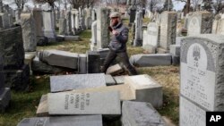 FILE - Headstones, pushed over by vandals, lay on the ground in the Mount Carmel Cemetery, a Jewish cemetery, in Philadelphia, Pennsylvania, Feb. 27, 2017.