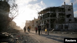 Palestinians walk amid the ruins of destroyed homes in the Shejaia neighbourhood, which witnesses said was heavily hit by Israeli shelling and air strikes during an Israeli offensive, in Gaza City, Aug. 6, 2014.