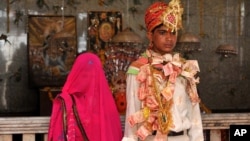 Newly wed Mamta Bai, 12, and her husband Bablu, 14, stands inside a temple in Rajgarh, about 155 kilometers (96 miles) from Bhopal, India, May 6, 2011.