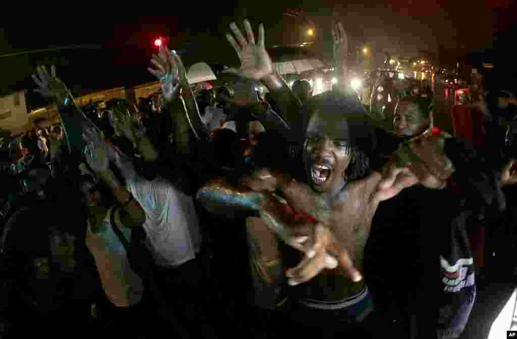 People defy a curfew, Aug. 17, 2014, before smoke and tear gas was fired to disperse a crowd in Ferguson.