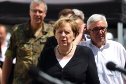 Kanselir Jerman Angela Merkel memberikan konferensi pers di kawasan yang dilanda banjir dekat Bad Neuenahr-Ahrweiler hari Minggu (18/7).