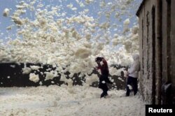 Una familia es atrapada en la espuma del mar en la costa de Bretaña después de que la tormenta Eleanor golpeara a Saint-Guenole en el oeste de Francia. Enero 3, 2017.