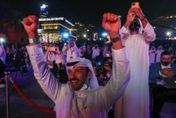 People react as they watch screens displaying information of the Hope Probe entering the orbit of Mars, in Dubai, United Arab Emirates, February 9, 2021. (REUTERS/Christopher Pike)