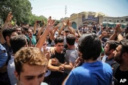A group of protesters chant slogans at the main gate of old grand bazaar in Tehran, Iran, June 25, 2018.