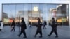 一队保安从北京一家苹果商店前走过。（2019年3月6日）