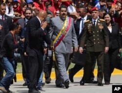 FILE - Gen. Ivan Hernández, head of both the presidential guard and military counterintelligence, right, keeps an eye on Venezuela's President Nicolas Maduro as he arrives for a military parade at Fort Tiuna in Caracas, Venezuela, Feb. 1, 2017.