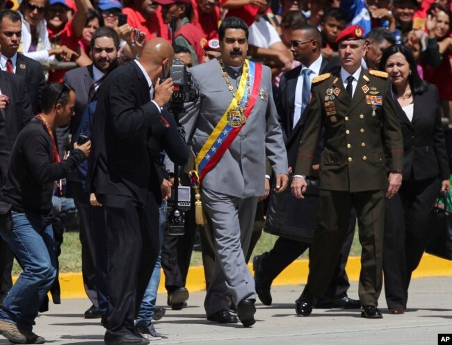 FILE - Gen. Ivan Hernández, head of both the presidential guard and military counterintelligence, right, keeps an eye on Venezuela's President Nicolas Maduro as he arrives for a military parade at Fort Tiuna in Caracas, Venezuela, Feb. 1, 2017.