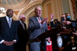 Senate Majority Leader Chuck Schumer, D-N.Y., center, speaks to reporters following a Democratic policy meeting at the Capitol in Washington, Nov. 2, 2021.