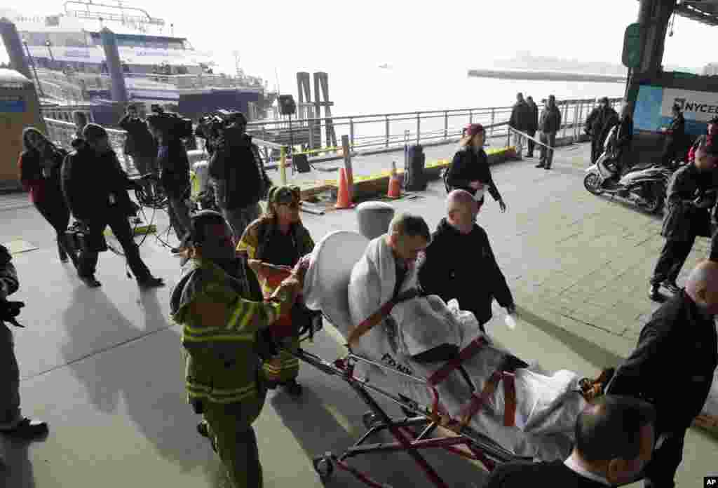 一名在撞上纽约码头的渡轮上受伤的乘客2013年1月9日被抬上担架
