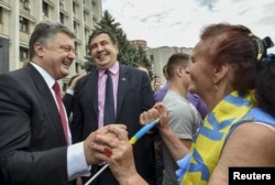 FILE - Ukrainian President Petro Poroshenko, left, and then-Governor of Odessa region Mikheil Saakashvili are greeted by a local resident near the regional state administration in Odessa, May 30, 2015.
