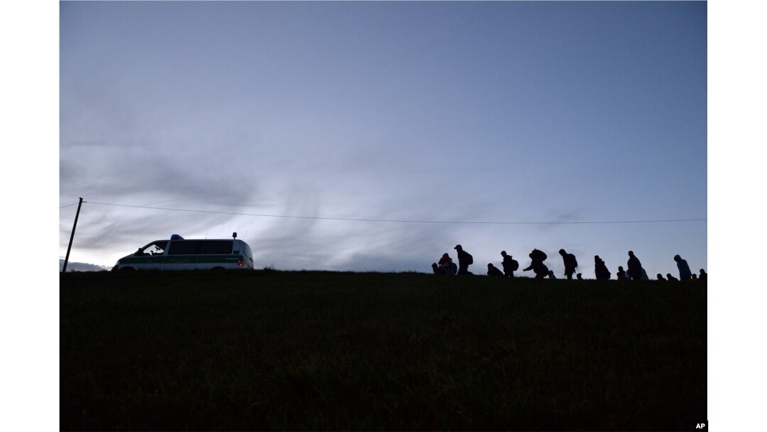 German federal police officers guide a group of migrants on their way after crossing the border between Austria and Germany in Wegscheid near Passau, Germany, Oct. 28, 2015.