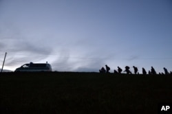 German federal police officers guide a group of migrants on their way after crossing the border between Austria and Germany in Wegscheid near Passau, Germany, Oct. 28, 2015.