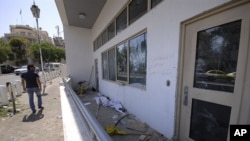 A man checks the damaged U.S. embassy after pro-government protesters attacked the embassy compound in Damascus, Syria, July 11, 2011