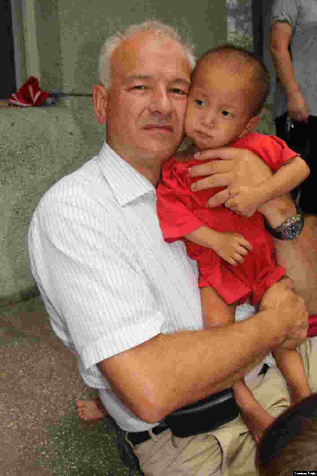 북한 황해남도 해주의 고아원에서 영양실조에 걸린 아이를 안고 있는 킴 하르츠너 미션 이스트 사무국장. (미션 이스트 제공)