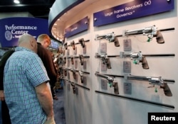 FILE: Gun enthusiasts look over Smith & Wesson guns at the National Rifle Association's (NRA) annual meetings and exhibits show in Louisville, Kentucky.